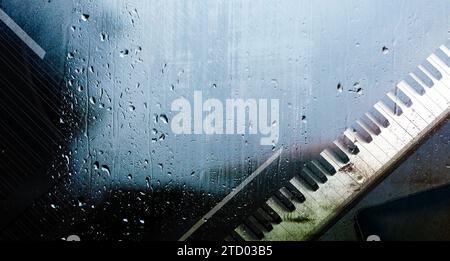 Klavier hinter dem Fenster mit Wassertropfen an einem regnerischen Tag.Entspannen Sie Musik für die Reise.Klaviermusik Konzept abstrakter Hintergrund. 3D-Abbildung Stockfoto