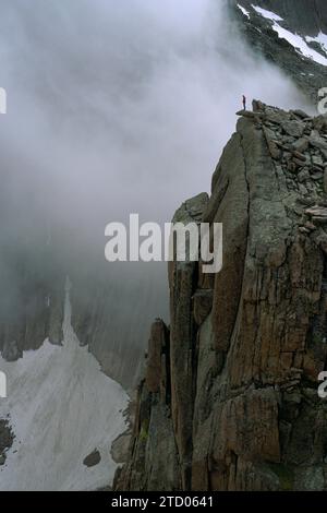 Ein Mann steht auf einem Berggipfel. Stockfoto