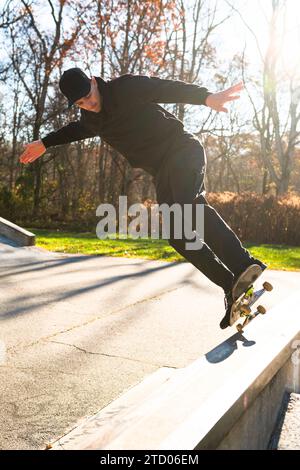 Solo-Mann-Skateboarden auf einer Skatepark-Rampe im Herbst Stockfoto