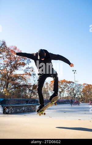 Solo-Mann-Skateboarden im Herbst im A Skatepark Stockfoto