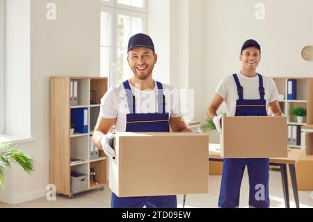 Mitarbeiter eines Umzugsunternehmens oder eines Lieferdienstes, die Kartons zusammen tragen Stockfoto
