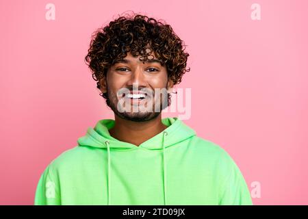 Porträt des lächelnden Freundes, der gutaussehende arabische Kerl trägt trendiges grünes Sweatshirt mit gleichem Ausdruck isoliert auf rosa Hintergrund Stockfoto