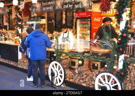 Kunden, die Speisen und Getränke an einem Verkaufsstand kaufen, Weihnachtsmesse 2023, Vorosmarty ter, Vorosmarty Square, Budapest, Ungarn Stockfoto