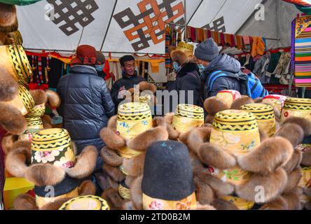(231215) -- XIGAZE, 15. Dezember 2023 (Xinhua) -- Menschen kaufen Hüte auf einer Messe im Kangmar County von Xigaze, südwestchinesische Autonome Region Xizang, 13. Dezember 2023. Die fünftägige Messe schloss am 14. Dezember im Kangmar County in Xigaze, das mehr als 200 freie Verkaufsstände für Händler zur Verfügung stellte. (Xinhua/Jigme Dorje) Stockfoto