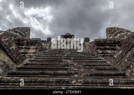 Eine antike Steintreppe führt zu einem Tempel unter einem dramatischen Himmel im Angkor Wat Komplex in Kambodscha. Stockfoto