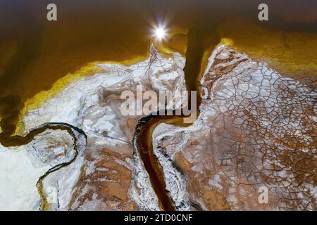 Atemberaubende Luftaufnahme der sonnengeküssten, farbenfrohen Wasserstraßen von Riotinto, die einzigartige Texturen und Muster von natürlichen Elementen enthüllen. Stockfoto