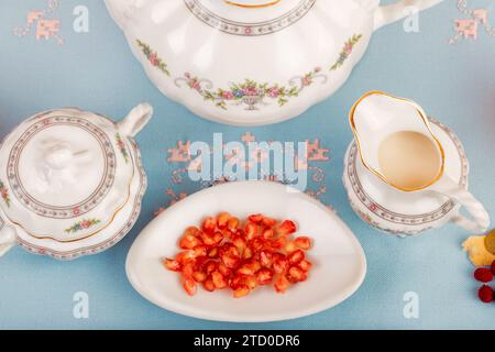 Ein Vintage Porzellan Teeset mit Goji-Beeren auf einem Teller, die Einrichtung auf einem pastellblauen Hintergrund. Stockfoto