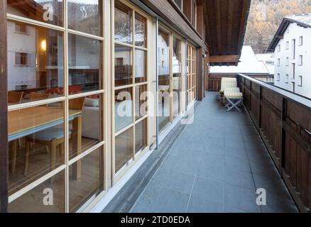 Ein charmanter Balkon mit Blick auf die traditionelle Schweizer Architektur und das Matterhorn aus der Ferne. Stockfoto