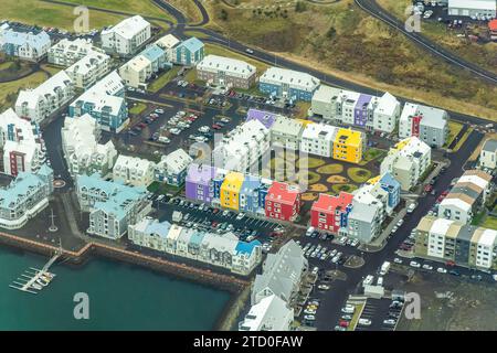 Aufnahmen über dem Kopf, die die lebhaften, bunten Dächer und Straßen von Reykjaviks urbaner Landschaft im Kontrast zum Küstenrand darstellen. Stockfoto