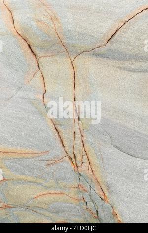 Nahaufnahme einer beigefarbenen Marmoroberfläche mit komplexen orange und grauen Adern Stockfoto