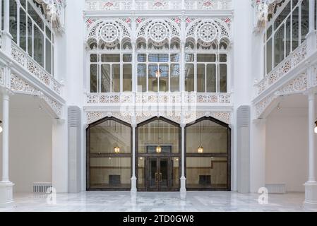 Helles weißes, leeres Bibliotheksflur mit Oberlicht und Lichtern, die im Flur mit Schnitzereien hängen Stockfoto