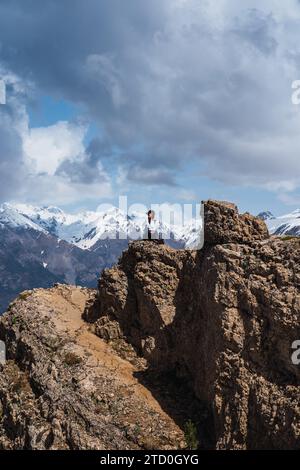 Eine Wanderer genießt den herrlichen Blick auf die schneebedeckten Gipfel von einem Felsvorsprung in den Pyrenäen im Ordesa-Nationalpark in der Nähe von Torla, Huesc Stockfoto