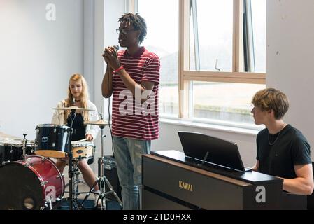 Eine Gruppe von Studenten probt für ihre Bands-Auftritte im Musikzimmer des College. Stockfoto