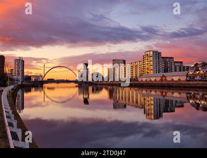 Hinter der berühmten Squinty Bridge über den Fluss Clyde in Glasgow entwickelt sich ein außergewöhnlich schöner Winteruntergang Stockfoto