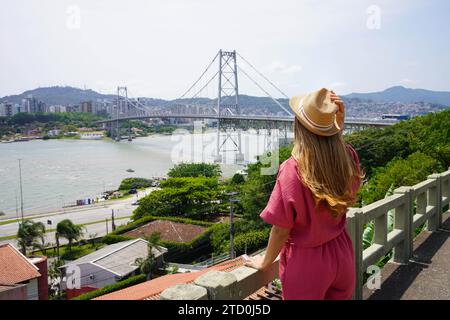 Tourismus in Florianopolis, Brasilien. Rückansicht eines wunderschönen Reisenden Mädchens mit Blick auf die Hercilio Luz Brücke in Florianopolis, Brasilien. Sommerurlaub Stockfoto