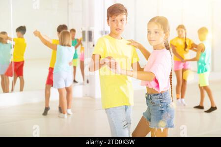 Jungen und Mädchen genießen aktiven Tanz im Studio Stockfoto