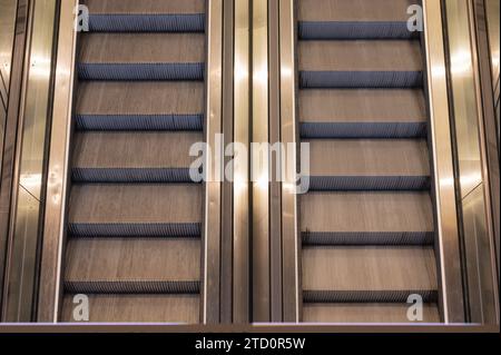 Ein Paar Rolltreppen, die von einem Bahnhof zu einem Flughafenterminal führen, von oben gesehen. Stockfoto