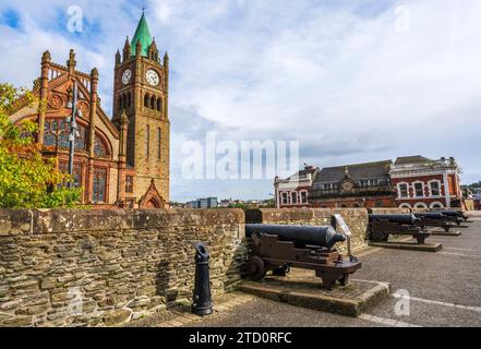 Guildhall in Derry-Londonderry, Nordirland, erbaut im 19. Jahrhundert und der Uhrenturm, von den Mauern mit Kanonen gesehen Stockfoto