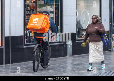 Essen Sie einfach einen Fahrer auf einem Schubrad, der eine Essenslieferung in Cork, Irland, macht. Stockfoto