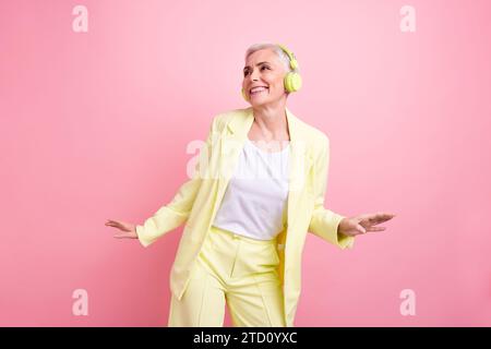 Foto einer hübschen Geschäftsinhaberin tragen einen gelben formellen Anzug, der sich im Büro ausruhen kann, um Musik auf rosa Hintergrund zu hören Stockfoto