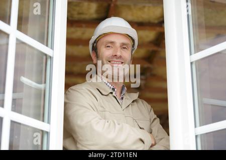 Bauarbeiter stand an offenen Fenstern Stockfoto