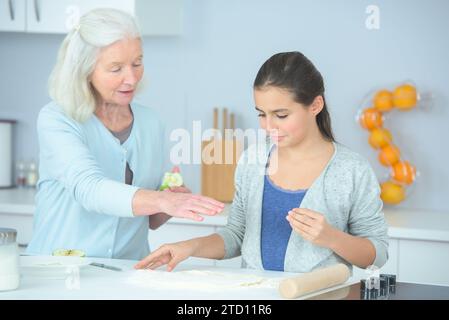 Enkelin mit Oma kocht zusammen Stockfoto