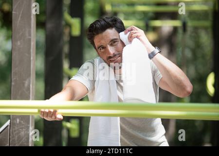 Gutaussehender Mann, der eine Pause von Pull-ups auf der horizontalen Bar hat Stockfoto