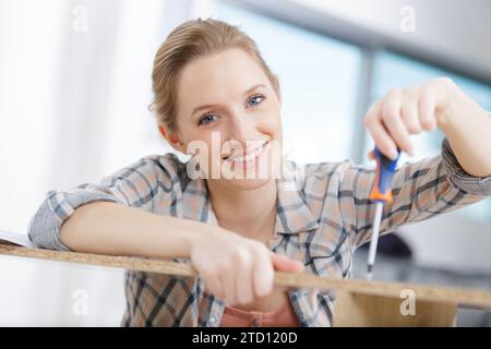 Eine Zimmerfrau bohrt ein Loch in eine Holzplanke Stockfoto