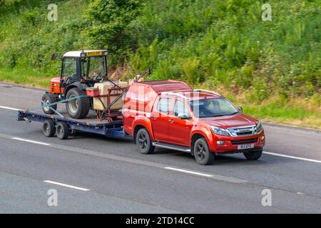 DASSELBE Società Accomandita Motori Endotermici, italienische Landmaschinen. Ein Traktor, der von Isuzu D-Max Utah Vision D/C TW Trbtd TD 163 4WD Red LCV Double Cab gezogen wird, nimmt 2499 ccm Diesel-Van auf, der im Großraum Manchester, Großbritannien, unterwegs ist Stockfoto