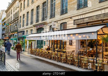 Eine Frau sitzt auf der Außenterrasse im Le Petit Cadet, einem Bistro in der Rue Cadet im 9. Arrondissement, Paris, Frankreich Stockfoto