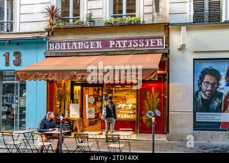 Leute außerhalb der Boulangerie Dupuy, einer Boulangerie, pâtisserie in der Rue Cadet im 9. Arrondissement von Paris, Frankreich Stockfoto