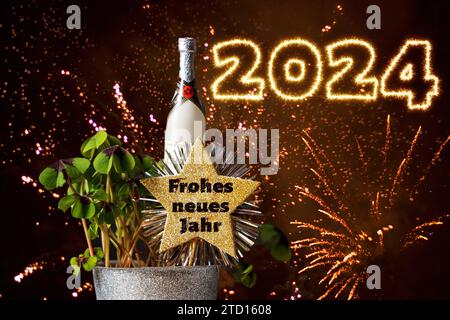 15. Dezember 2023: „Happy New Year“-Schriftzug auf einem goldenen Stern in einer Silvesterpflanze mit Glücksklee und Champagnerflasche. 2024 Feuerwerk Schriftzug FOTOMONTAGE *** Frohes Neues Jahr Schriftzug auf einem goldenen Stern in einer Silvesterpflanze mit Glücksklee und Sektflasche. 2024 Feuerwerksschrift FOTOMONTAGE Stockfoto