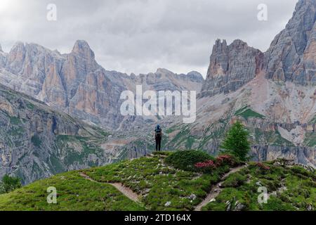 Eine weibliche Person in Cinque Torri, die das Tofane-Gebirge in den Dolomiten, Italien, bewundert. Fantastisches Ziel für Wanderer und Wanderer. Stockfoto