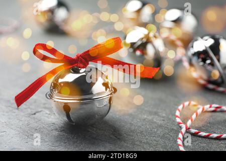 Weihnachtsmusik. Klingelglocken auf grauem Tisch, Bokeh-Effekt Stockfoto