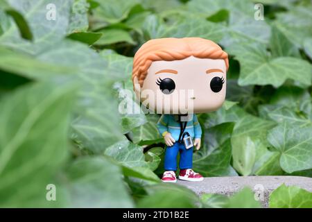 Funko Pop Actionfigur von Max Mayfield mit Kassettenspieler aus der Netflix TV-Serie Stranger Things. Grüne Efeublätter, verlassener Garten. Stockfoto