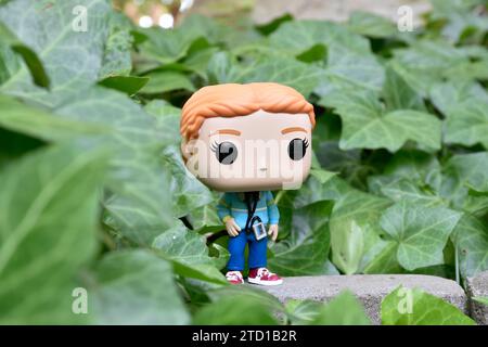 Funko Pop Actionfigur von Max Mayfield mit Kassettenspieler aus der Netflix TV-Serie Stranger Things. Grüne Efeublätter, verlassener Garten. Stockfoto