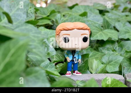 Funko Pop Actionfigur von Max Mayfield mit Kassettenspieler aus der Netflix TV-Serie Stranger Things. Grüne Efeublätter, verlassener Garten. Stockfoto