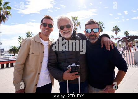 Fröhliches Porträt eines Vaters mit seinen erwachsenen Söhnen im Urlaub, die Kamera lächelnd anschauen. Stockfoto