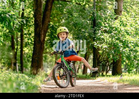 Ein Kind, das Fahrrad fahren lernt, kann das Gleichgewicht nicht halten und fällt herunter. Stockfoto