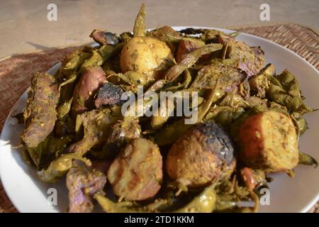 Umbadiyu ein traditionelles winterliches Gujarati-Spezialgericht, das mit Wintergemüse in einem Erdtopf, teilweise unterirdisch, gekocht wird und rauchiges Aroma und tas verleiht Stockfoto