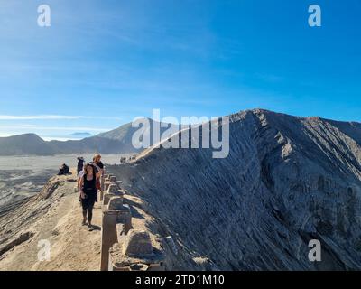 Touristen, die am Rand des Mount Bromo-Kraters in Ost-Java, Indonesien spazieren Stockfoto