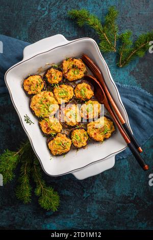 Im Ofen gebackene gefüllte Pilze - Champignons mit Frischkäse und getrockneten Tomaten in Auflauf Stockfoto