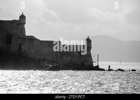 Stadt Guarujá, São Paulo, Brasilien. Sonnenuntergang in der Festung Santo Amaro da Barra Grande. Museum am Hafen von Santos Kanal. BW-Bild. Stockfoto