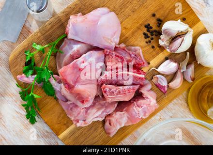 Portionierte Kaninchenbeine und Sattel mit Kräutern und Gewürzen Stockfoto