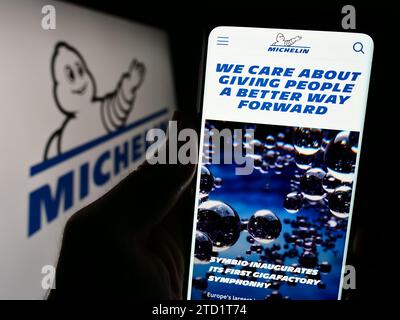 Person, die ein Handy hält, mit der Website der Compagnie Générale des établissements Michelin SCA vor dem Logo. Konzentrieren Sie sich auf die Mitte des Telefondisplays. Stockfoto