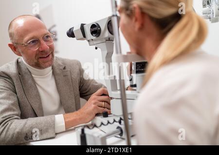 Mann, der sich einer Augenuntersuchung mit einer Spaltlampe in der Klinik unterzieht. Nahaufnahme. Gesundheitswesen und Medizinkonzept Stockfoto