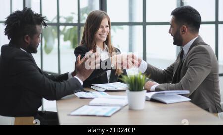 Drei selbstbewusste Geschäftsleute, die gemeinsam im Büro arbeiten Stockfoto