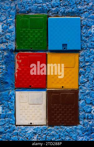 Elektrische Zählerboxen in verschiedenen Farben an einer blauen Wand in Chefchaouen, Marokko Stockfoto