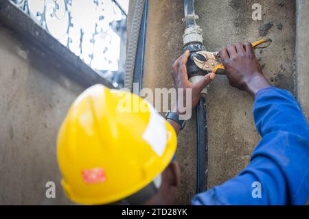 Nahaufnahme der Hände eines Klempners, der die Schrauben aus dem Wassersystem herausdrehen will. Stockfoto