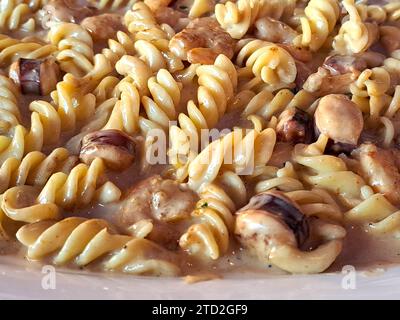 Köstliches Fusilli-Pastagericht in cremiger Sauce mit Meeresfrüchten wie Garnelen und Tintenfischen Stockfoto